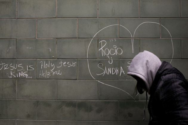 Una mujer camina por la calle junto a la pared de un refugio para personas sin casa en Skid Row, Los Ángeles. (AP/Jae C. Hong).
